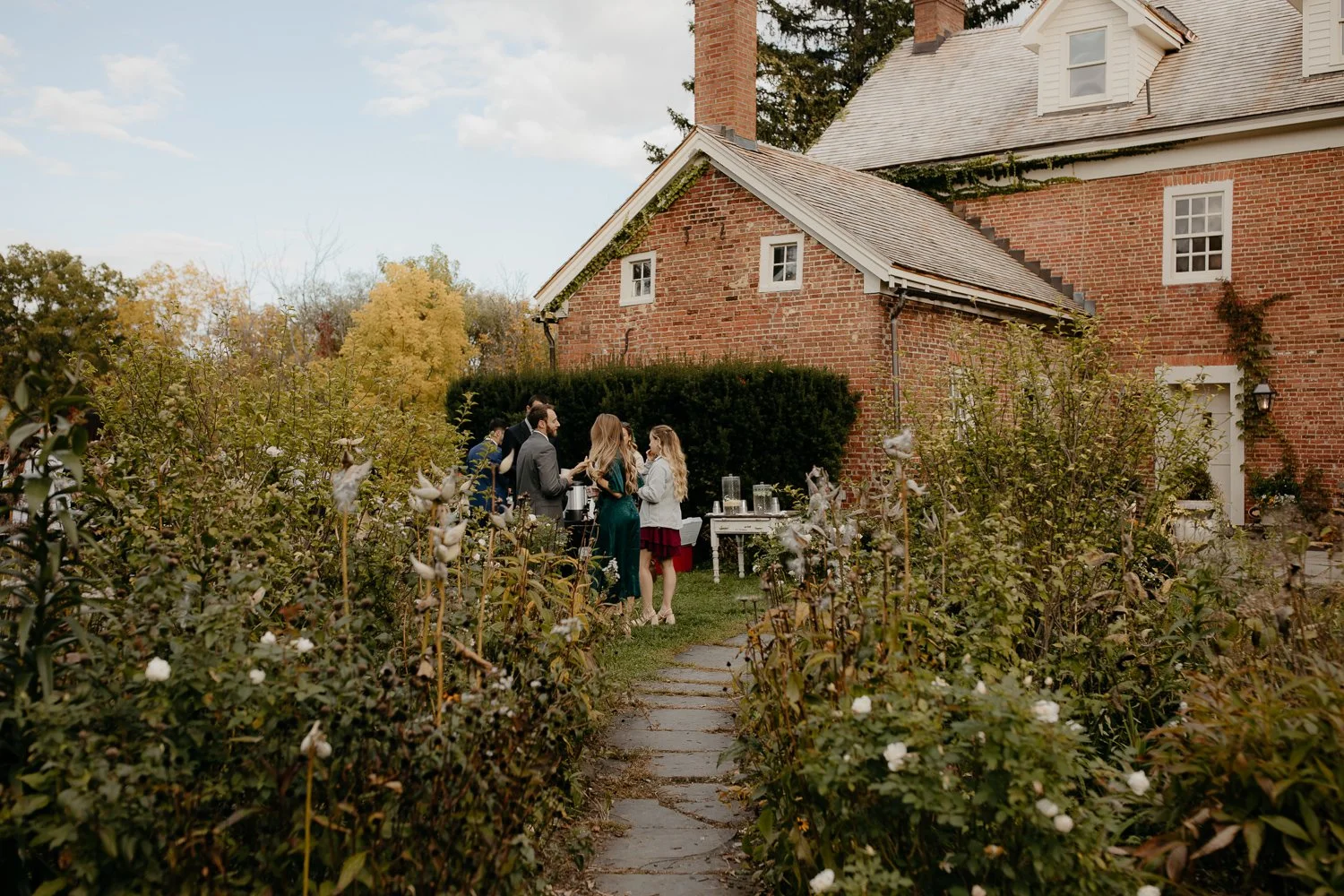 Guests mingling along the garden path during cocktail hour at Windrift Hall