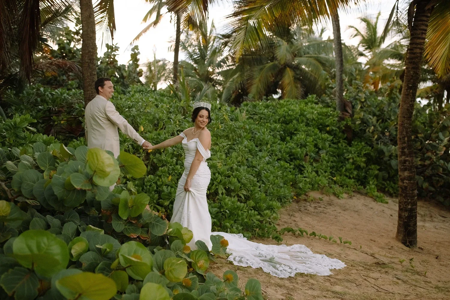 Bride and groom walking together along a tropical path during their destination wedding in Puerto Rico