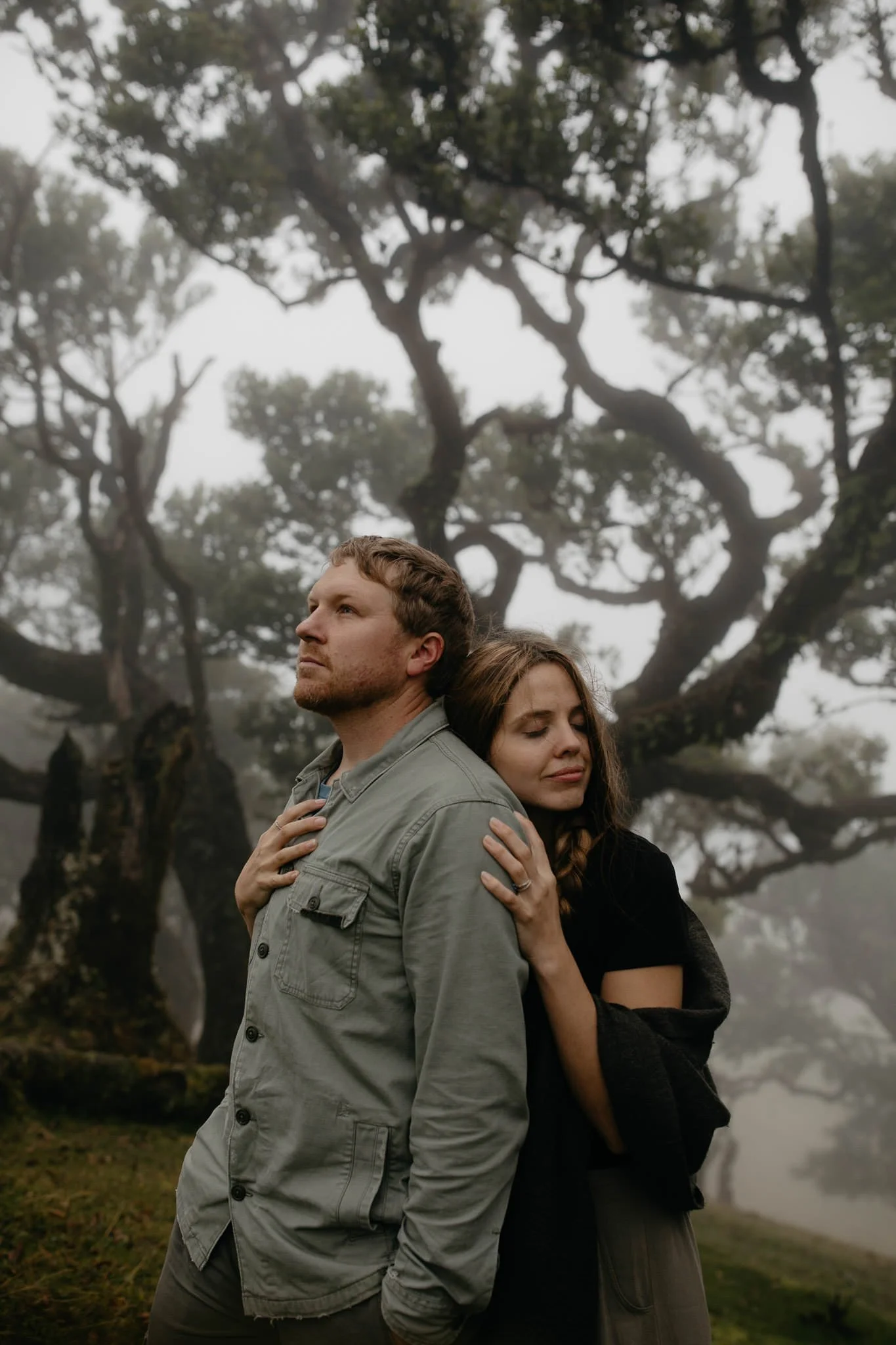 Couple standing together in a foggy forest landscape with soft natural light
