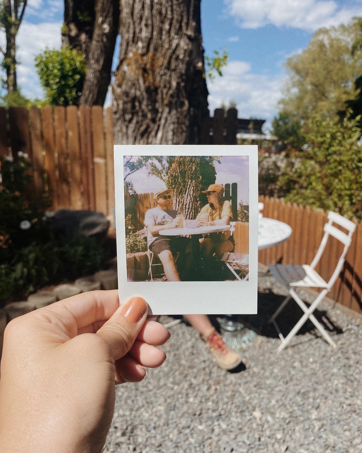 Polaroid photo held outside a cozy outdoor coffee shop patio in Jackson Hole
