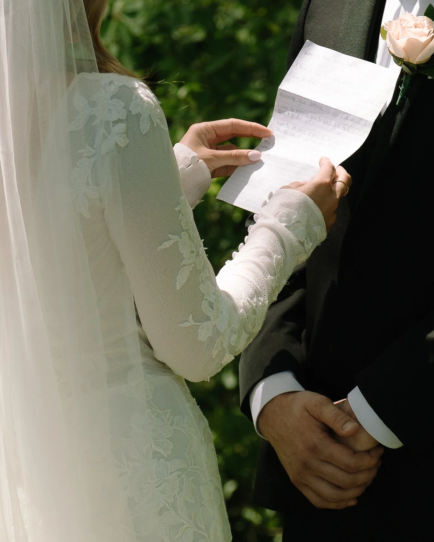 Close detail of bride holding her printed vows during a spring wedding at Jorgensen Farm The Gardens.