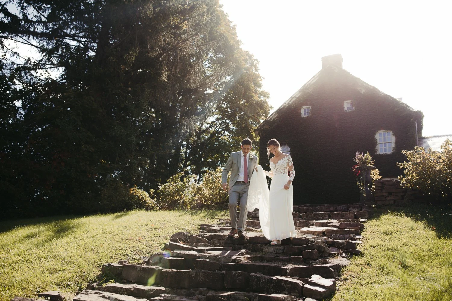Bride and groom walking down the historic stone steps at Windrift Hall during their Hudson Valley wedding