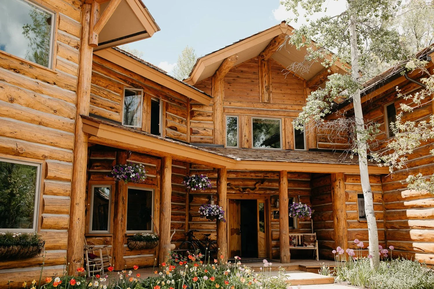 Large luxury log cabin Bentwood Inn near Jackson Hole, Wyoming surrounded by trees in summer