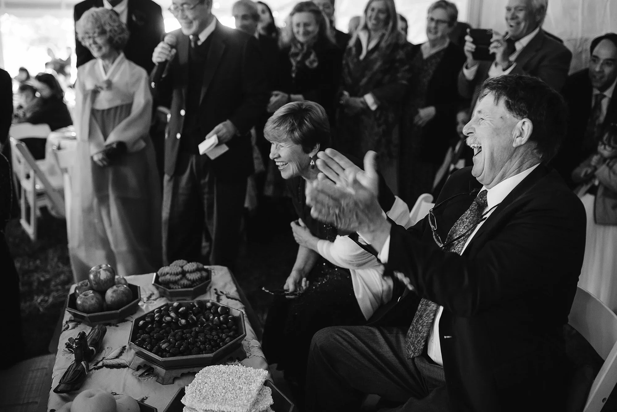 Candid wedding photo of family laughing during Paebaek ceremony, real emotional wedding moment