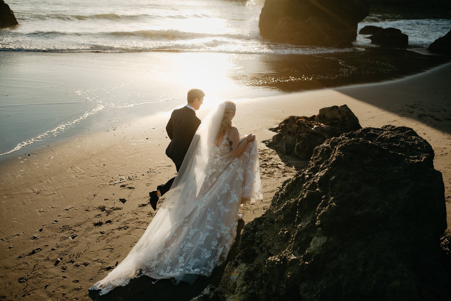 Couple walking along the shoreline toward sea stacks at College Cove in Trinidad California