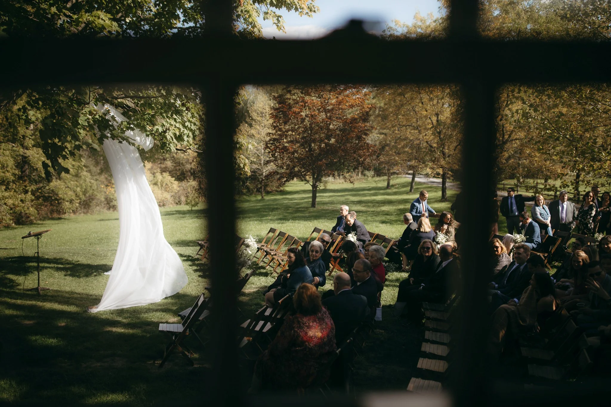 Guests gathered beneath a large oak tree during a Windrift Hall wedding ceremony in the Hudson Valley