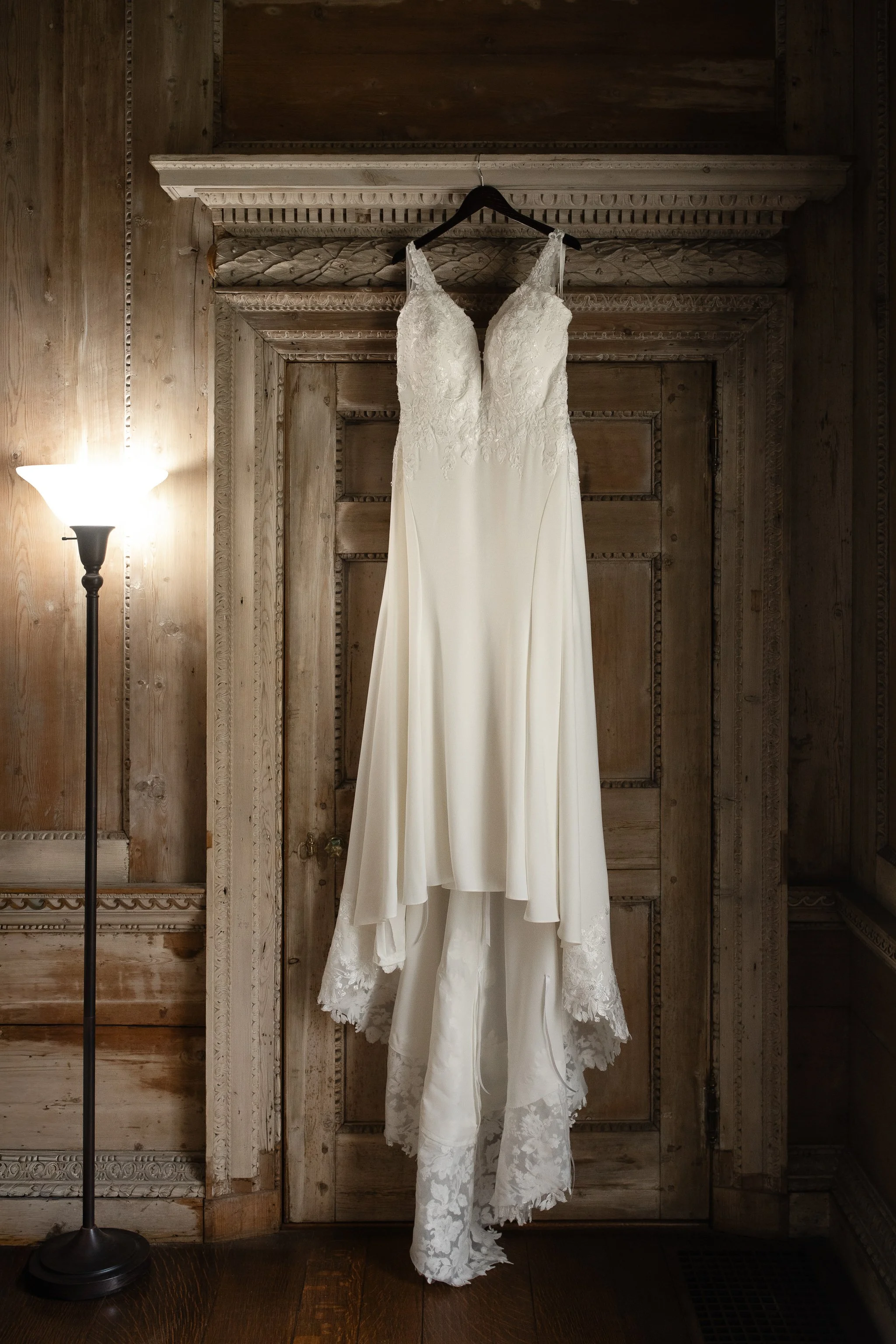 Wedding dress hanging in wood-paneled room at Peterloon Estate in Cincinnati