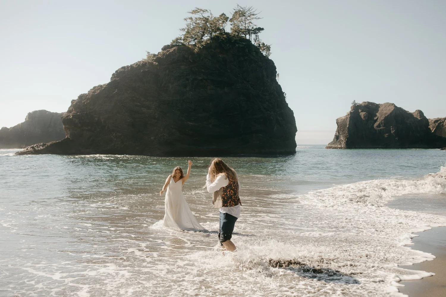 Couple laughing and splashing in the surf along the Samuel H. Boardman coastline