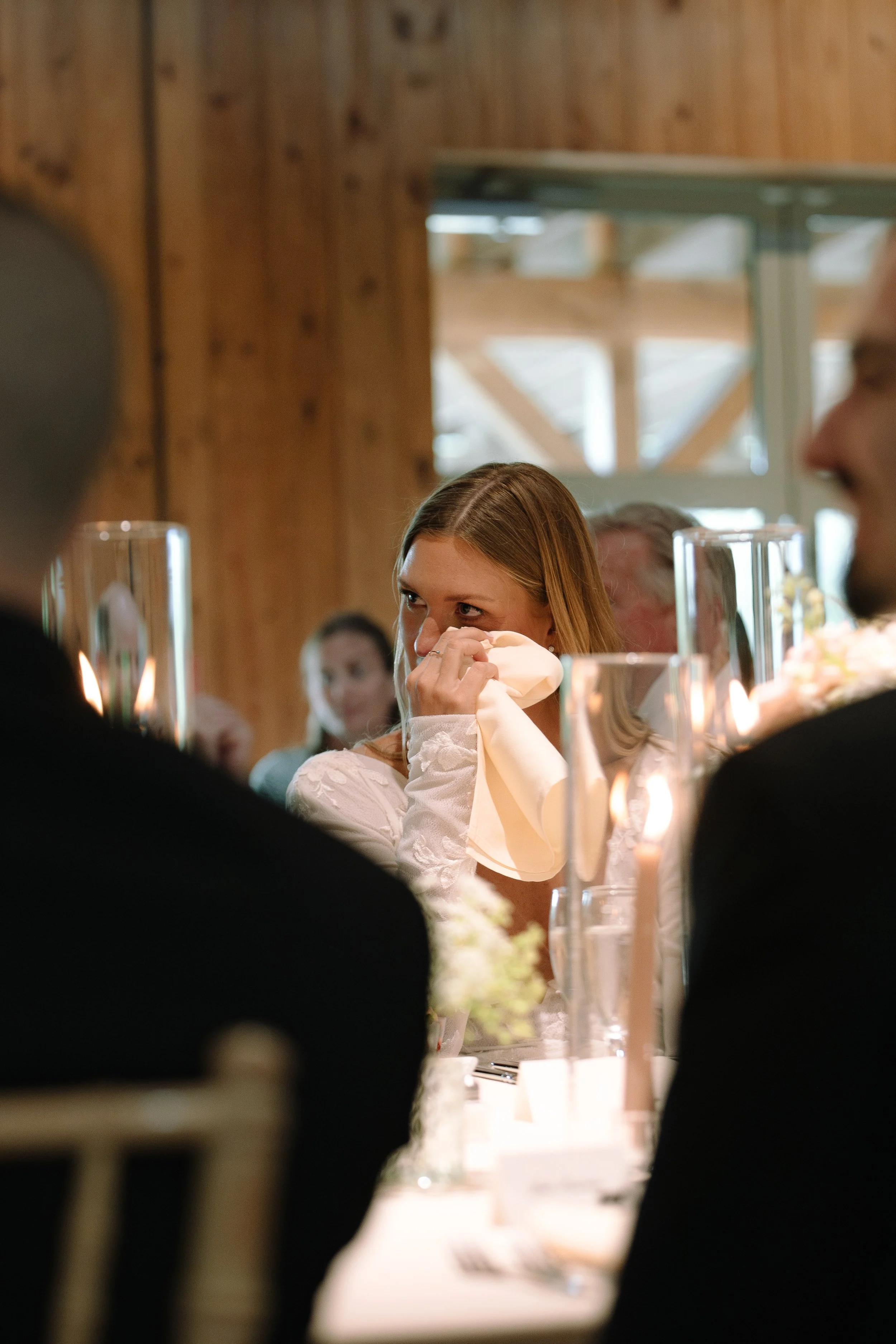Bride reacting emotionally during a speech inside the historic barn at Jorgensen Farms.