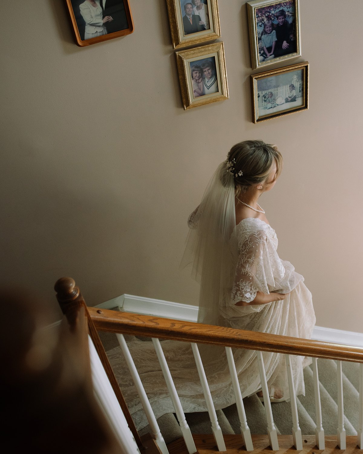 Bride walking down a staircase in soft window light at a Cincinnati wedding