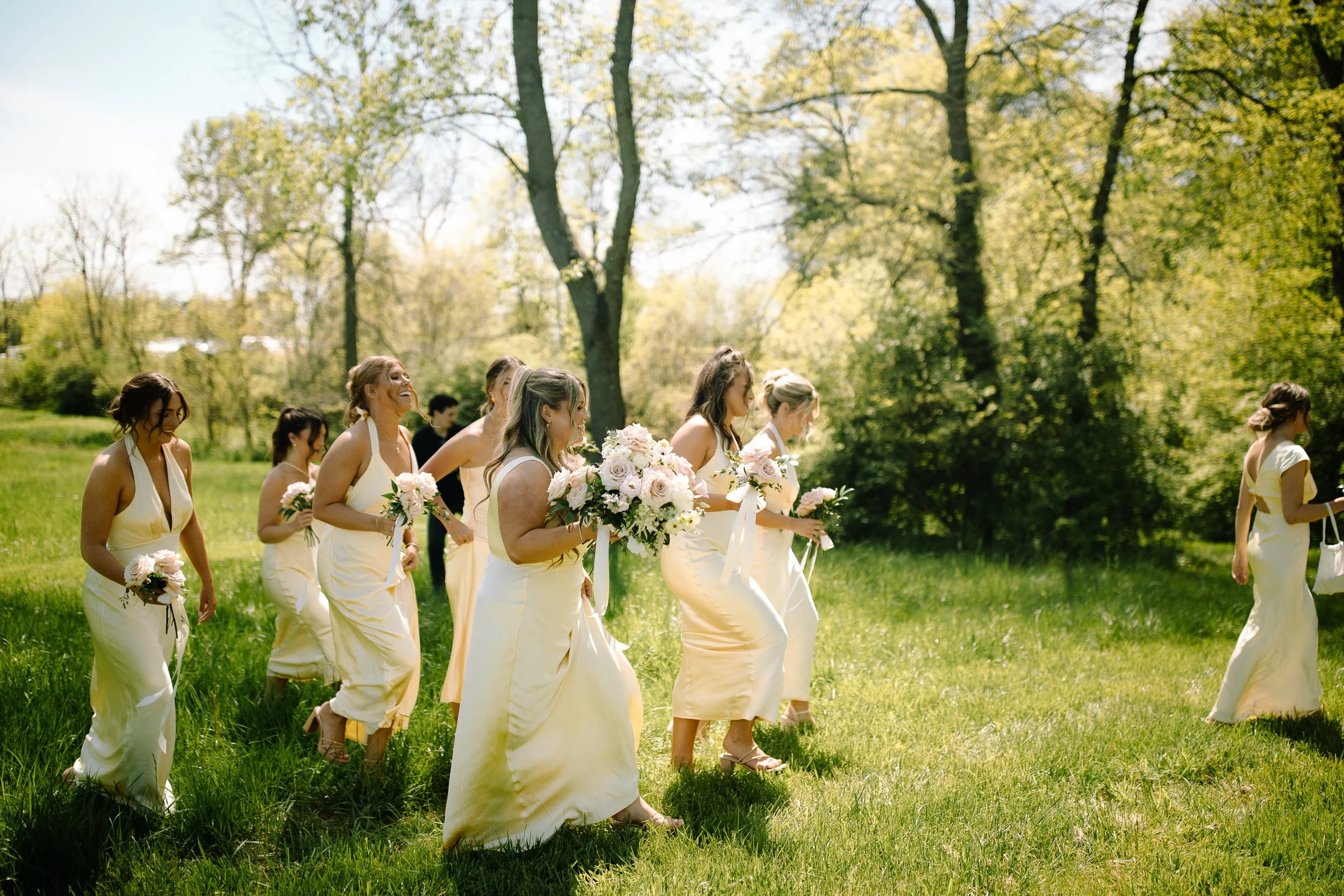 Bride and bridesmaids lined up in front of the Arboretum building at Jorgensen Farm The Gardens in Columbus, Ohio.
