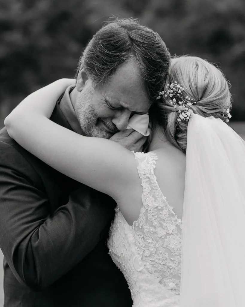 Bride embracing her father during an emotional first look moment on her wedding day.