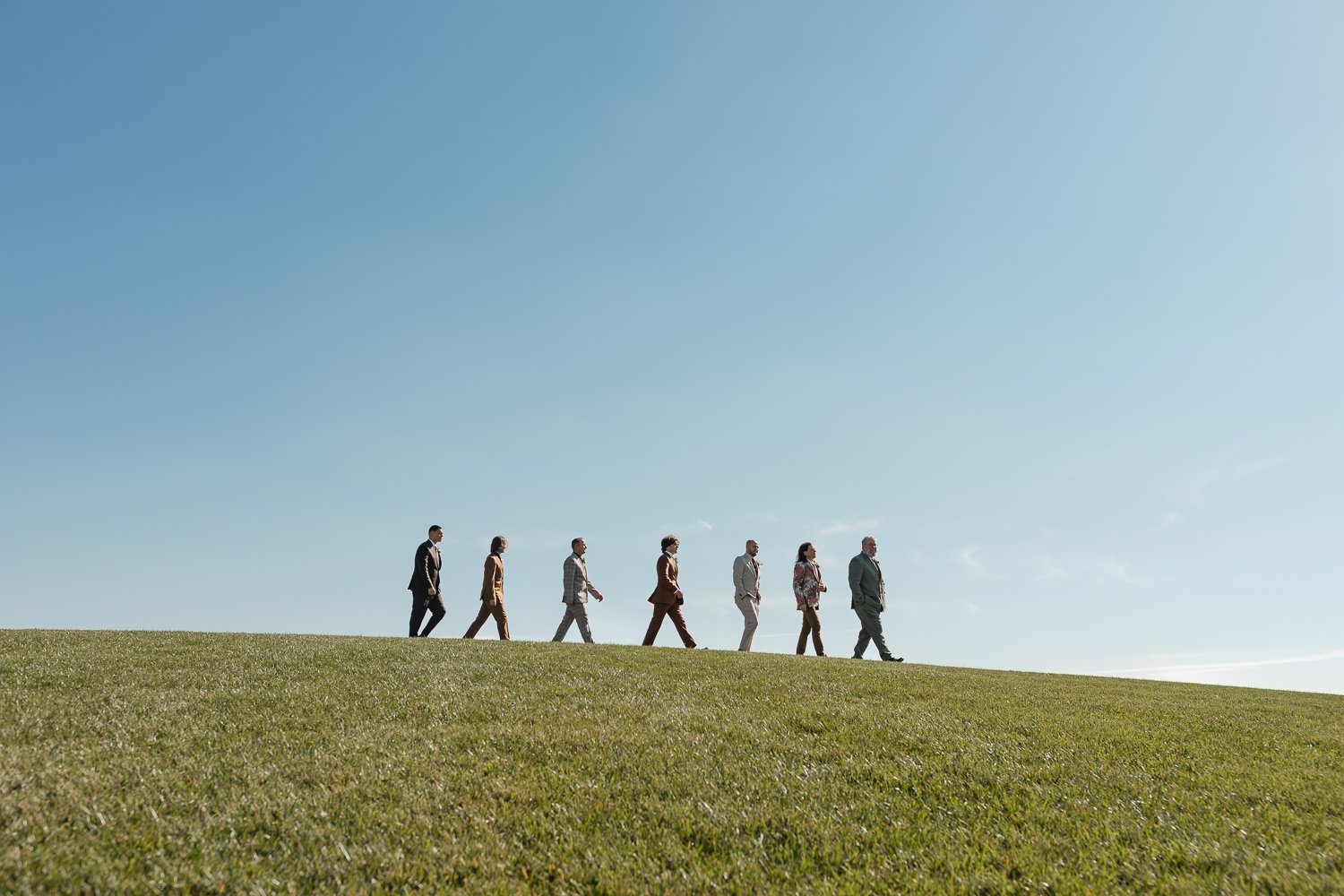 Wide portrait of groomsmen lined up on a hill during an Ivory Meadows wedding in Yellow Springs, Ohio.