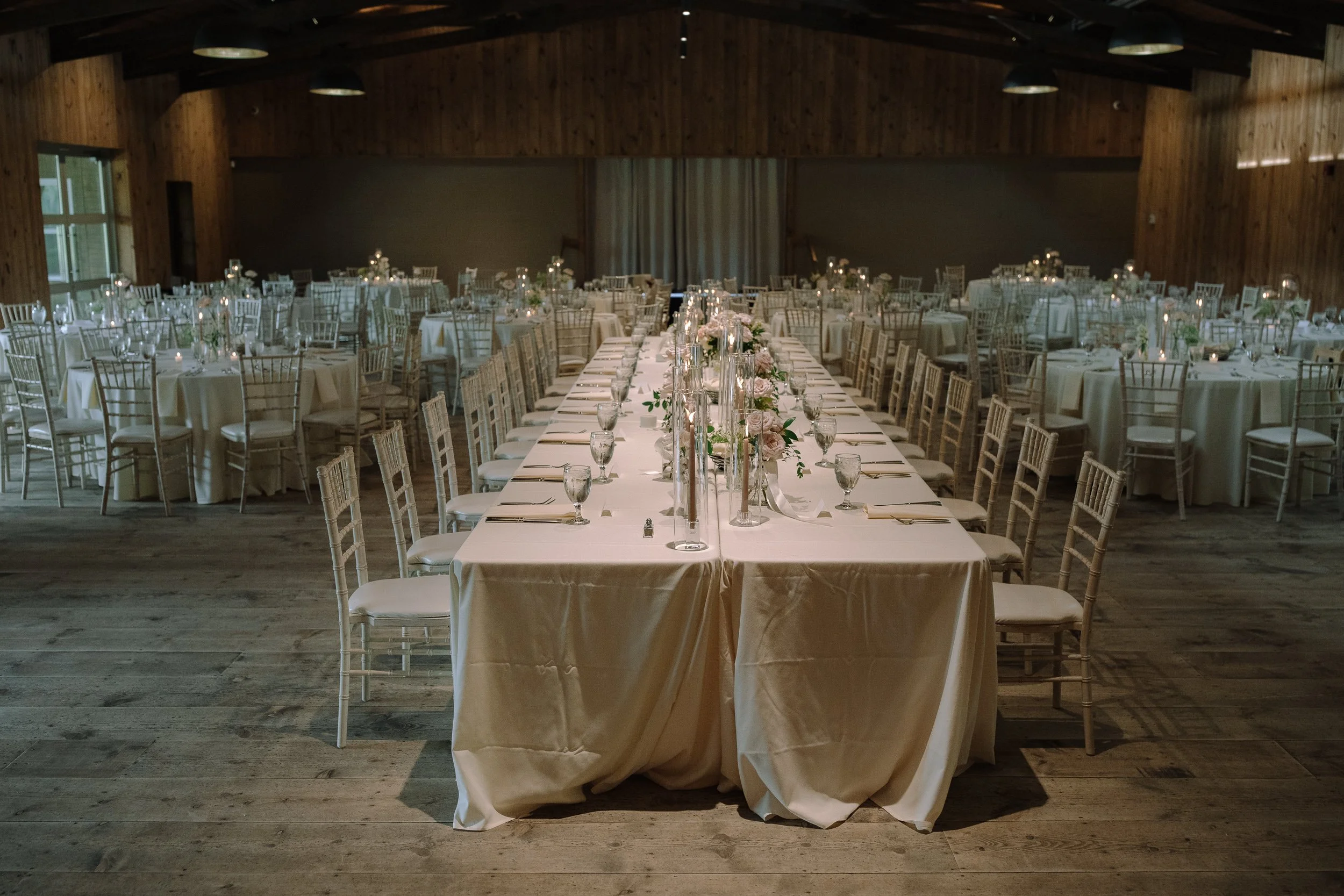 Wide view of long reception tables inside the historic barn at Jorgensen Farms in Columbus, Ohio.