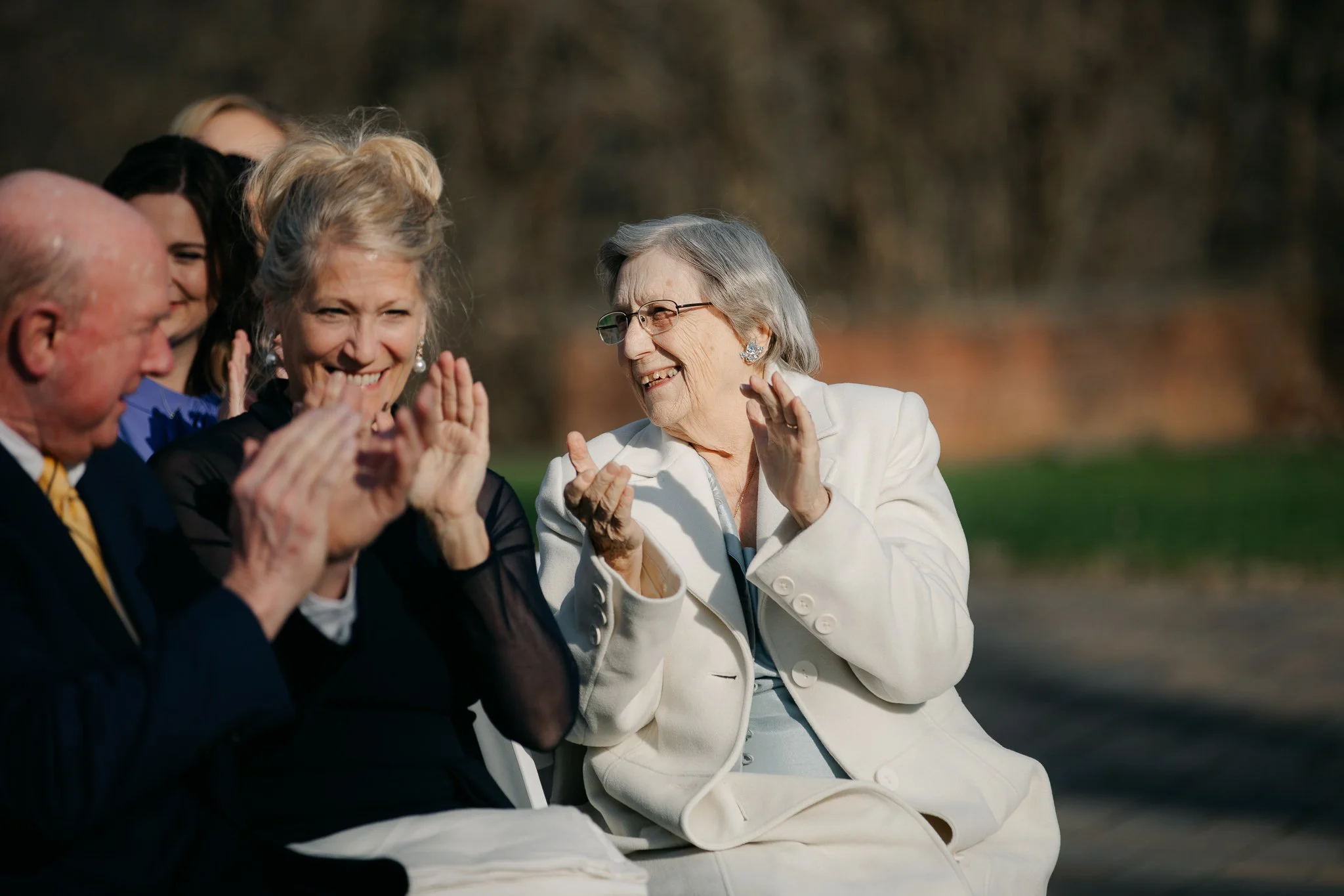 Family members clapping and smiling during ceremony celebration