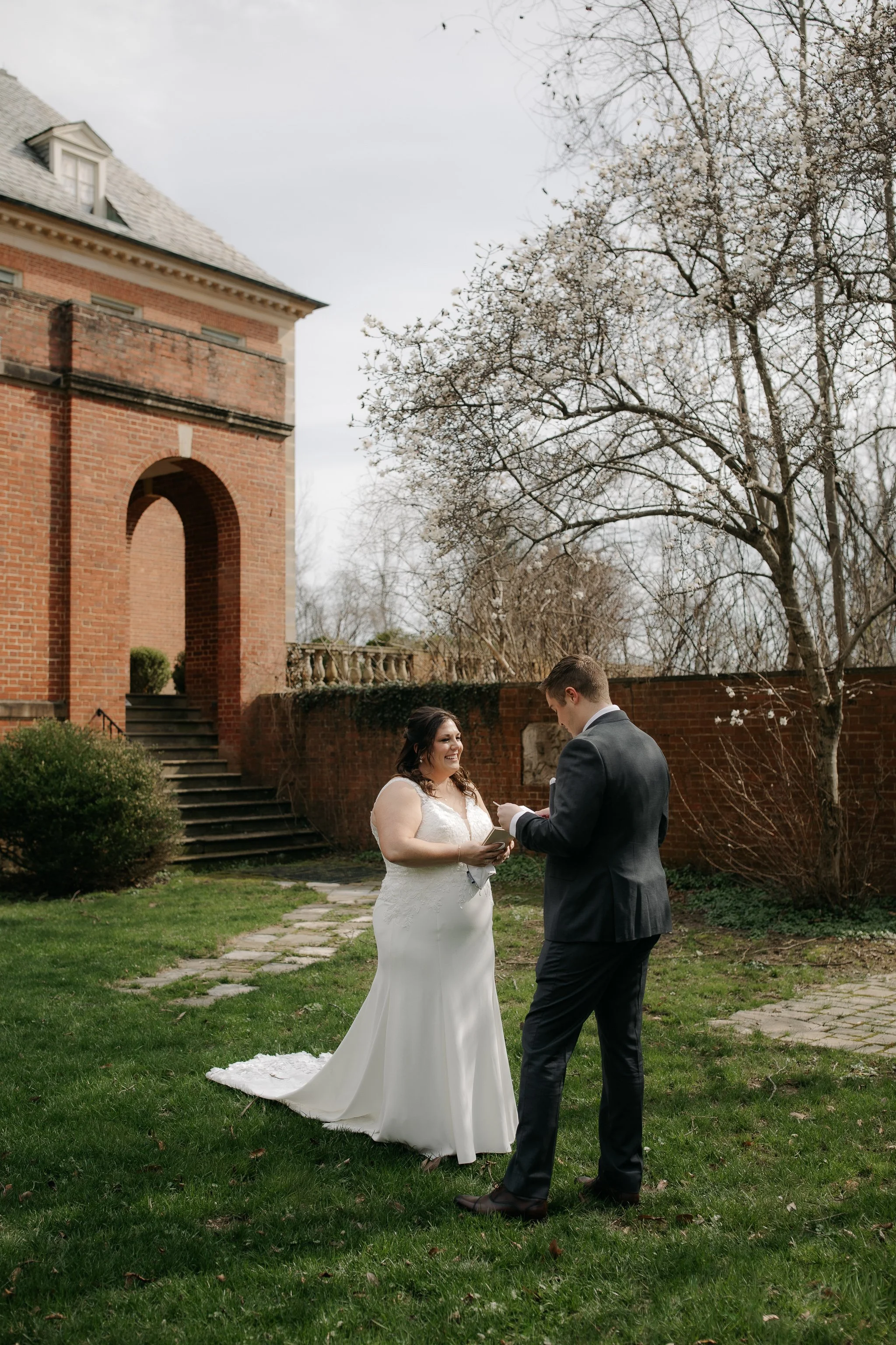 Bride and groom reading private vows in garden at Peterloon Estate in Cincinnati