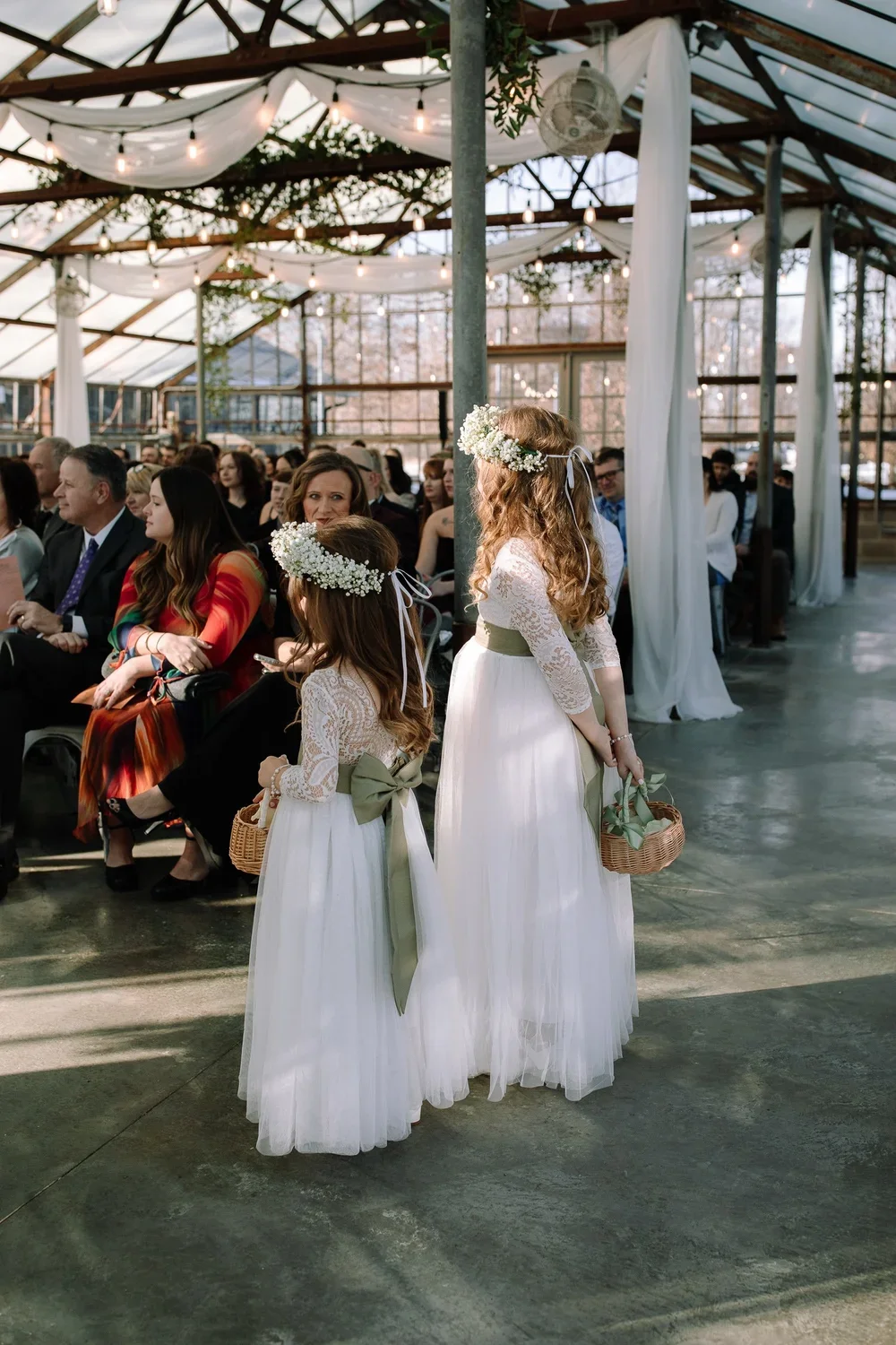 Flower girls waiting during ceremony inside Jorgensen Farms Greenhouse in Columbus, Ohio