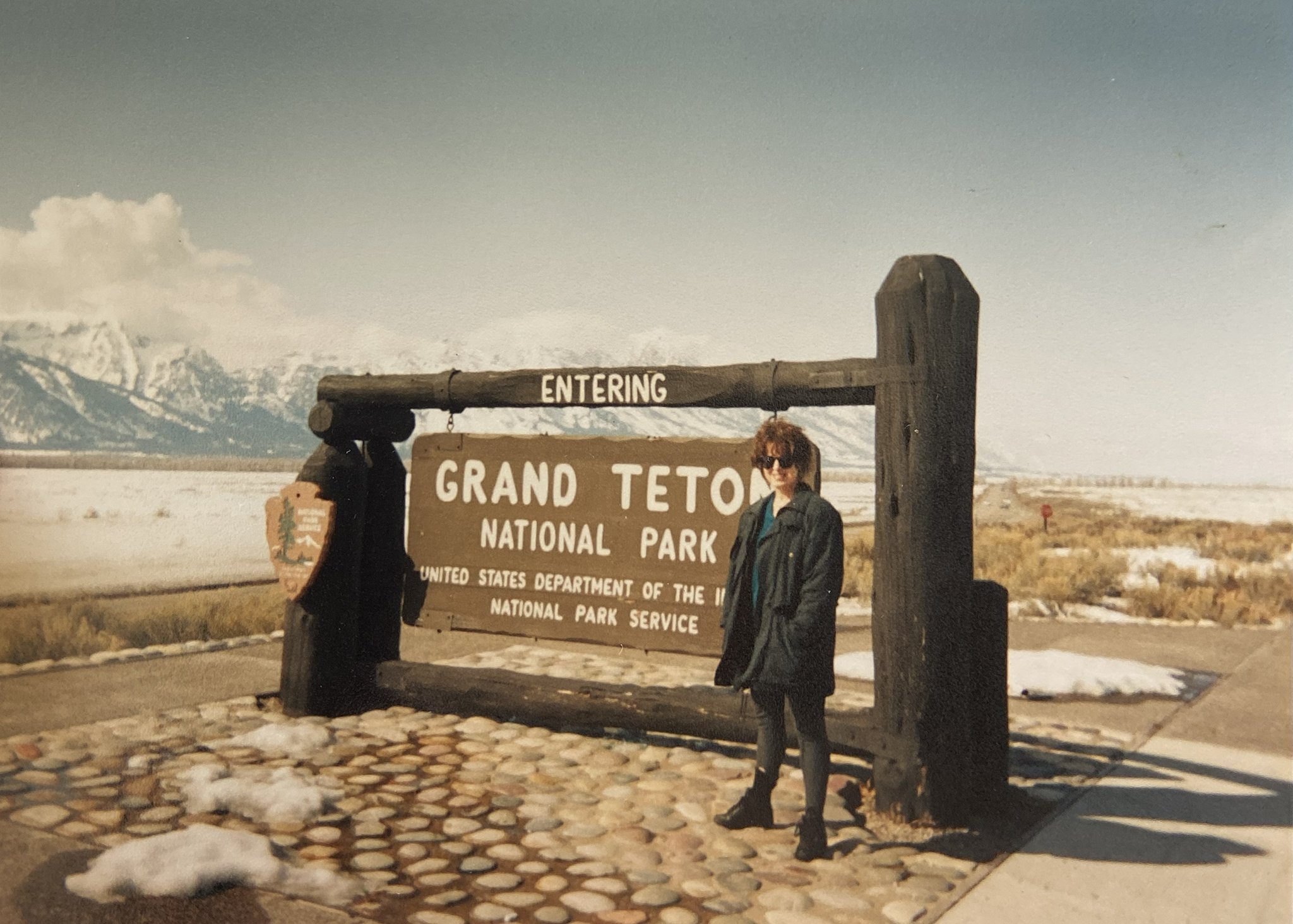 Vintage family photo at Grand Teton National Park entrance sign, old travel photograph in Wyoming