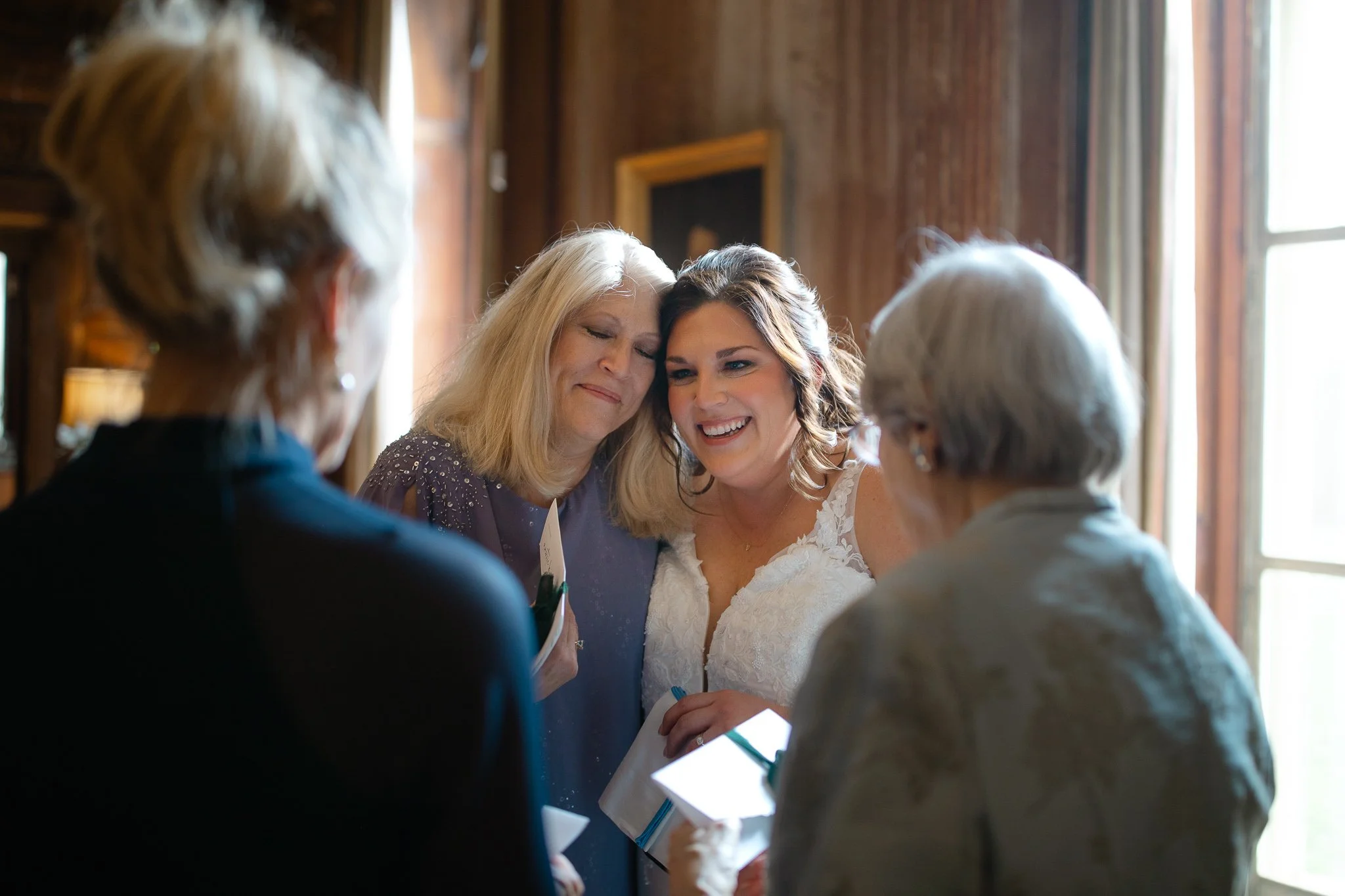 Bride sharing a candid moment with family near window light inside Peterloon Estate