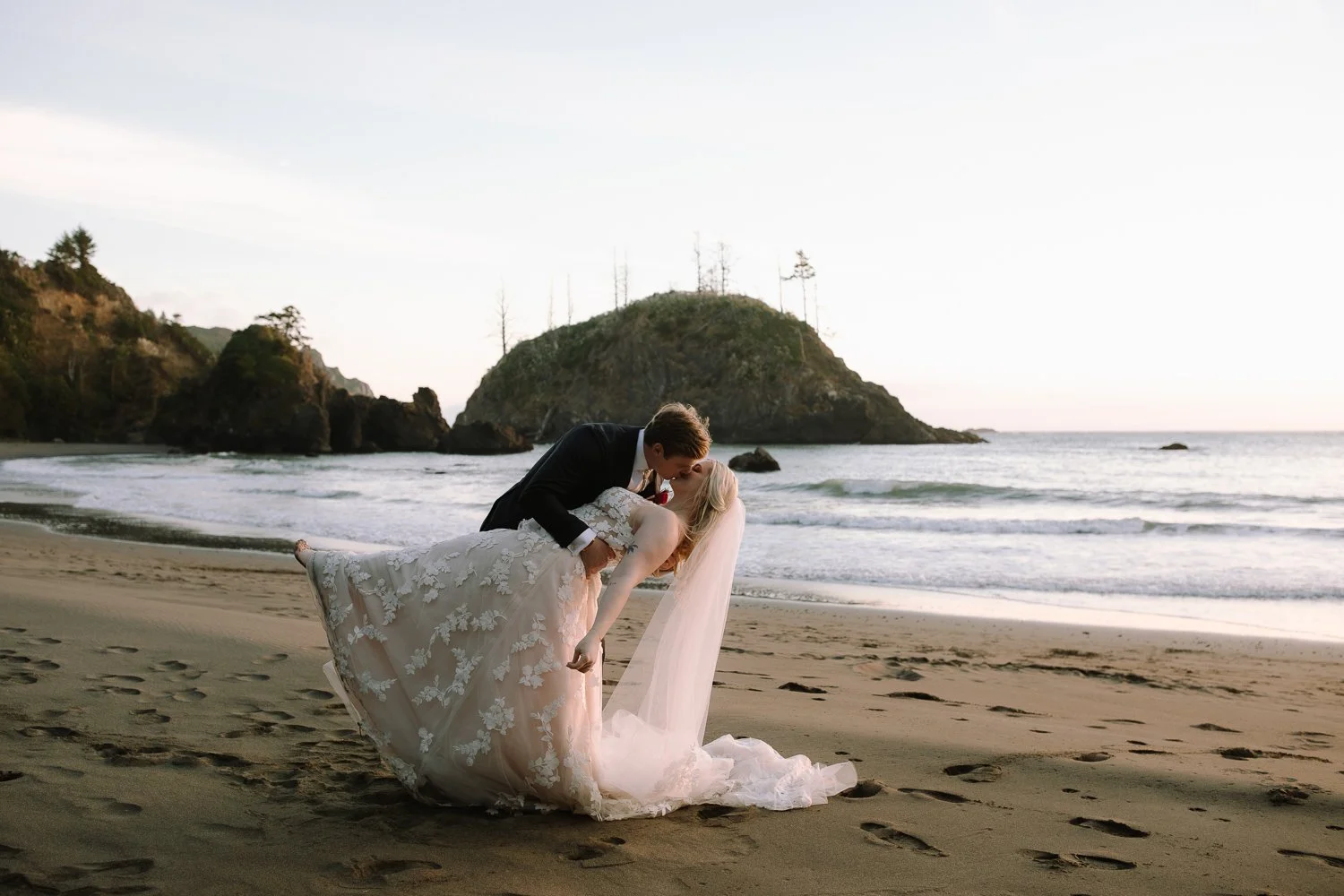 Couple sharing a dip kiss on a Northern California beach after their elopement