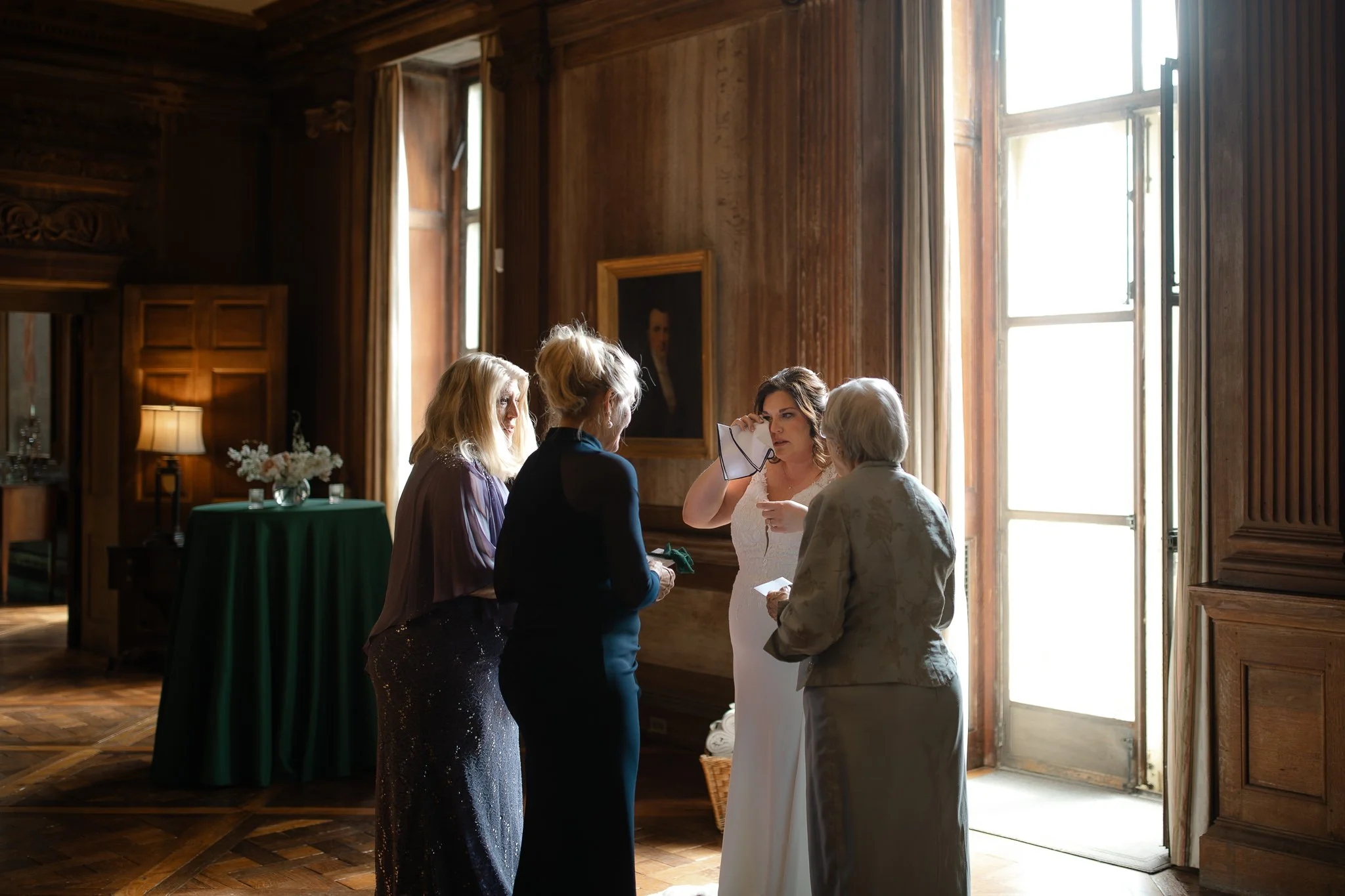 Wide view of Peterloon Estate grand room with family gathered near tall window