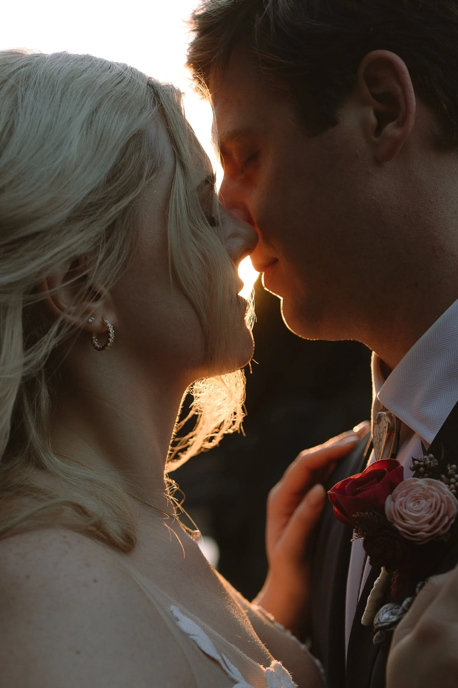 Bride and groom touching foreheads at sunset on the beach