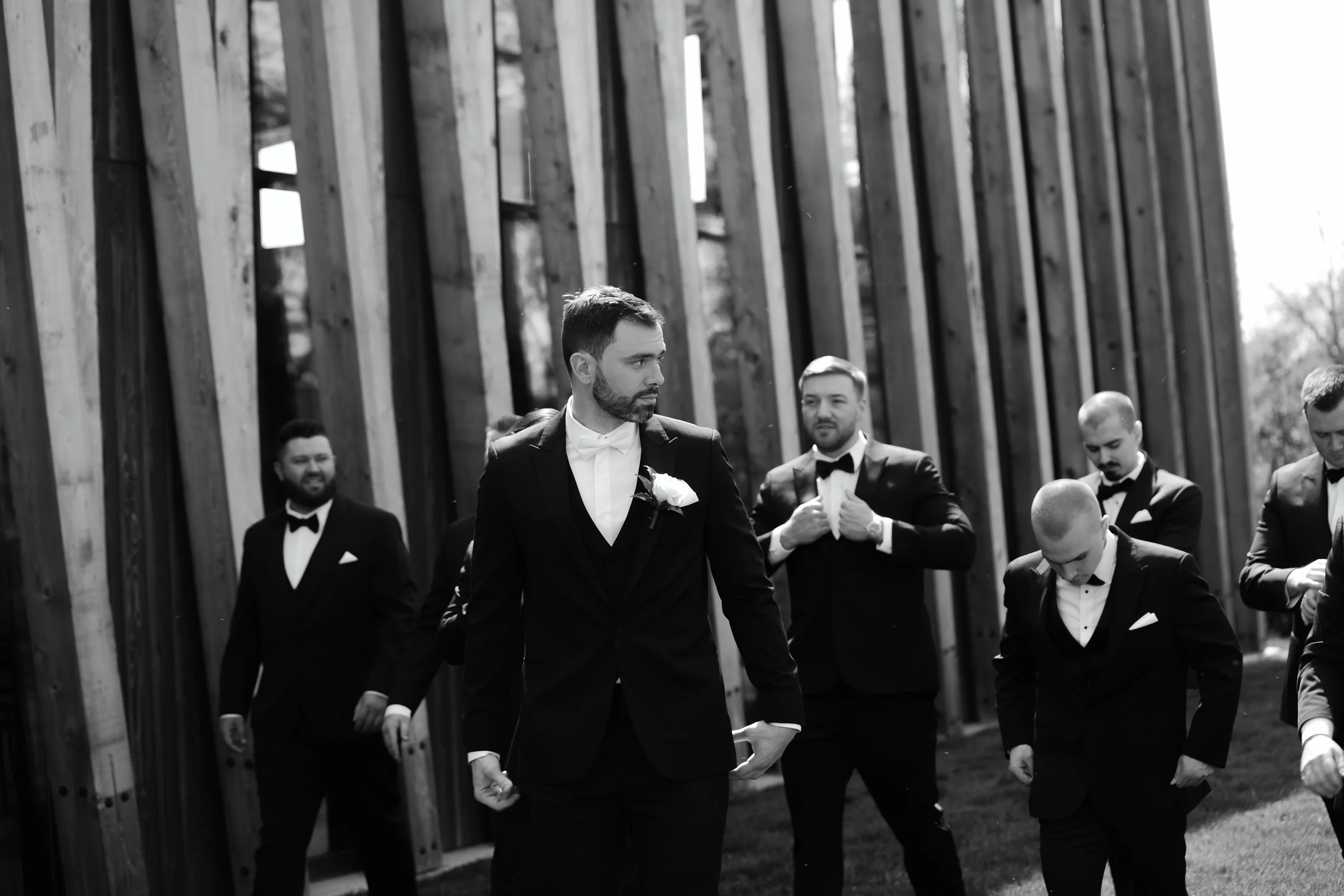 Groom and groomsmen walking outside the Arboretum building at Jorgensen Farm The Gardens in Columbus, Ohio.