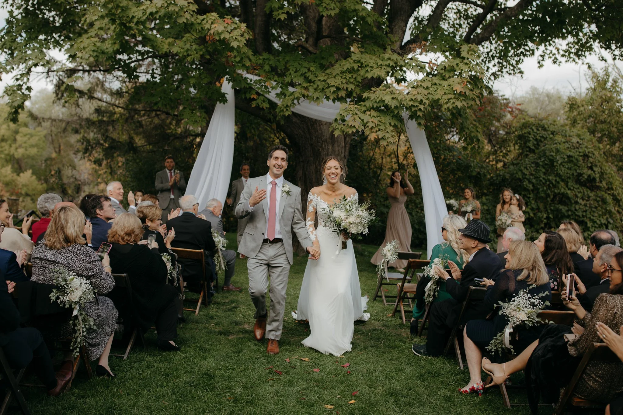 Bride and groom walking down the aisle after their outdoor ceremony at Windrift Hall in the Hudson Valley