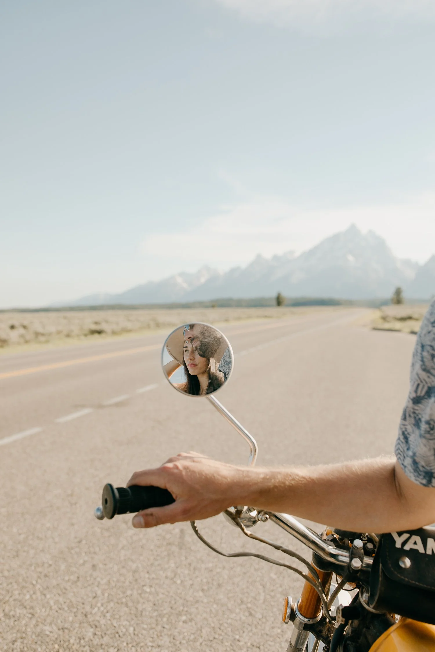 Close up of couple’s hands resting on motorcycle handlebars