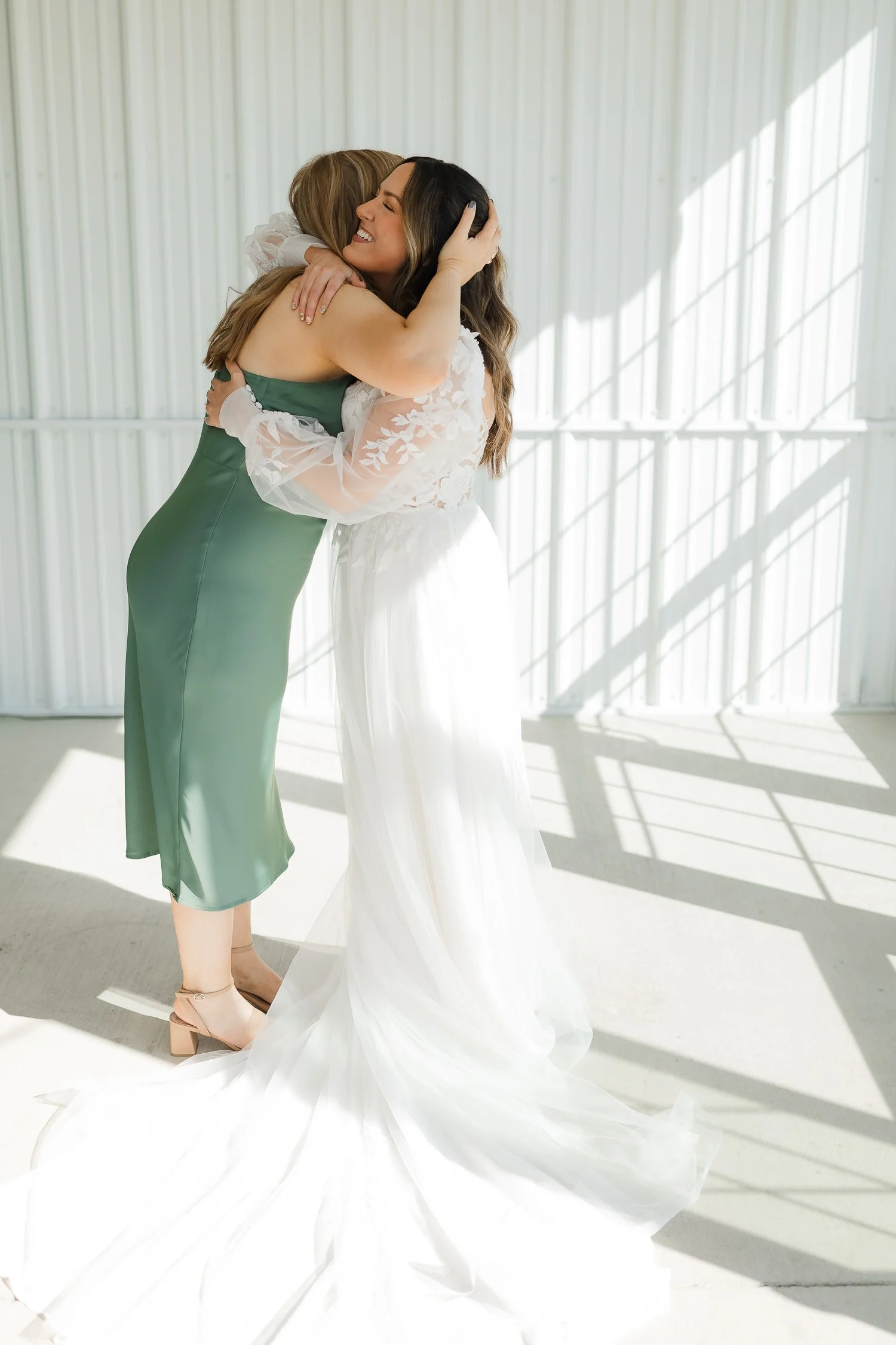 Bride sharing a hug with a bridesmaid during getting ready at an Ivory Meadows wedding in Yellow Springs, Ohio.