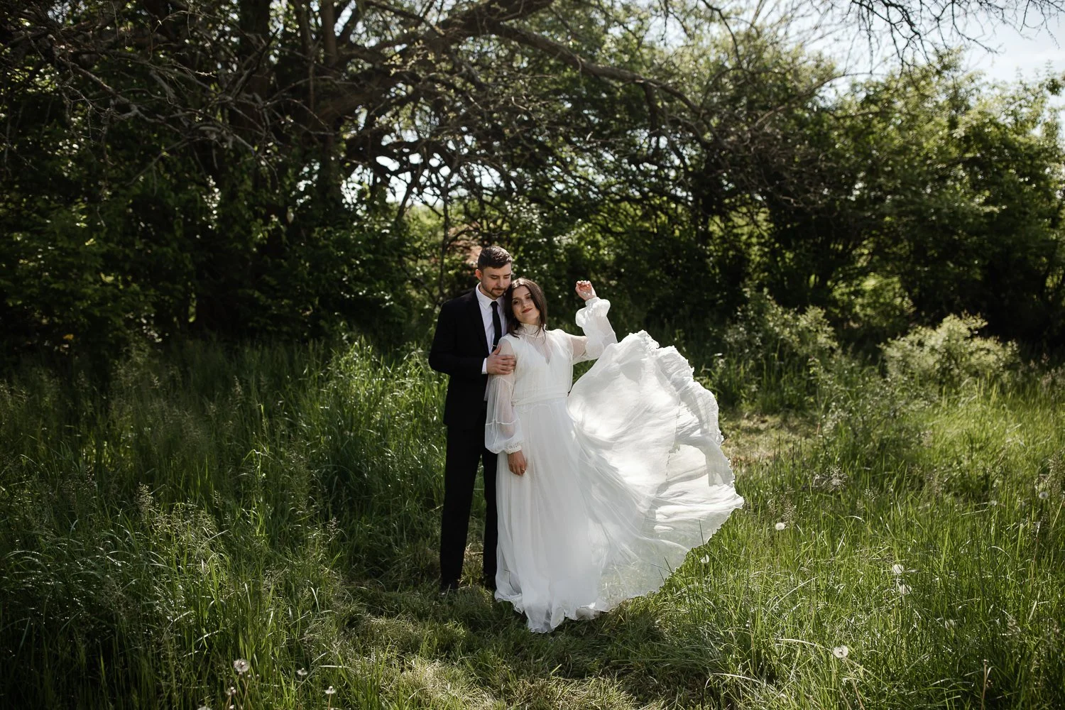 Couple standing together in tall grass during a vintage picnic wedding in Dayton, Ohio