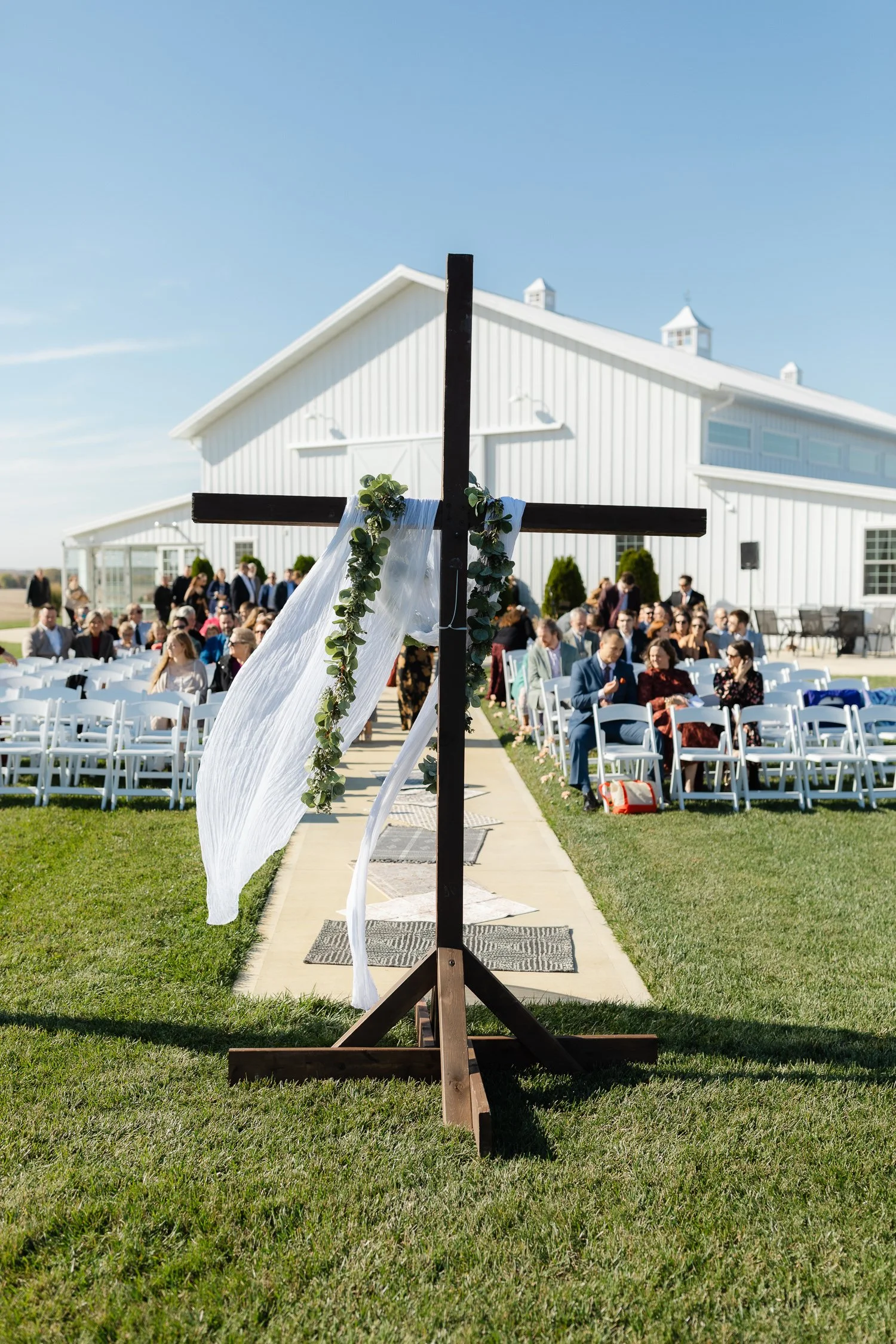 Outdoor ceremony setup with wooden cross and guest seating at Ivory Meadows in Yellow Springs, Ohio.