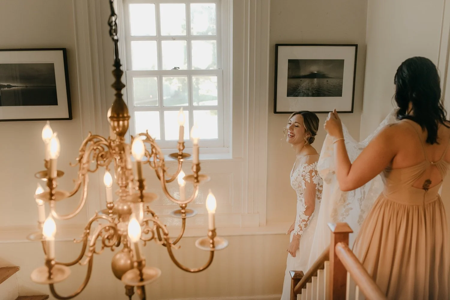 Bride getting ready inside Windrift Hall with warm window light and chandelier before her Hudson Valley wedding