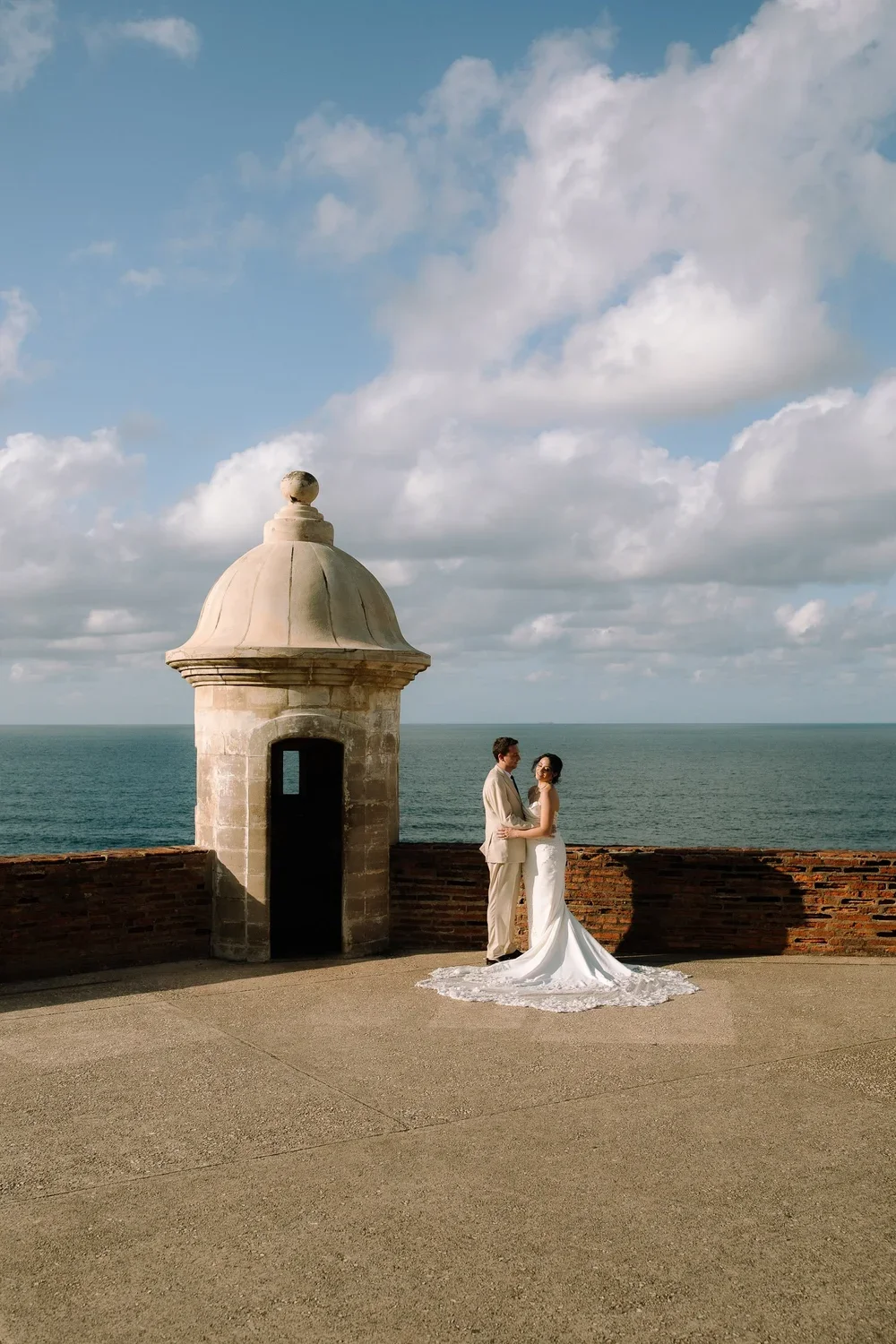 Wedding portraits in Old San Juan with a historic garita overlooking the ocean along the city walls of Puerto Rico.