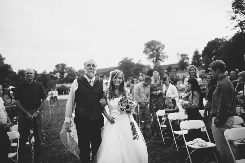 Emotional wedding photo of bride walking down the aisle with her father crying, meaningful candid wedding moment