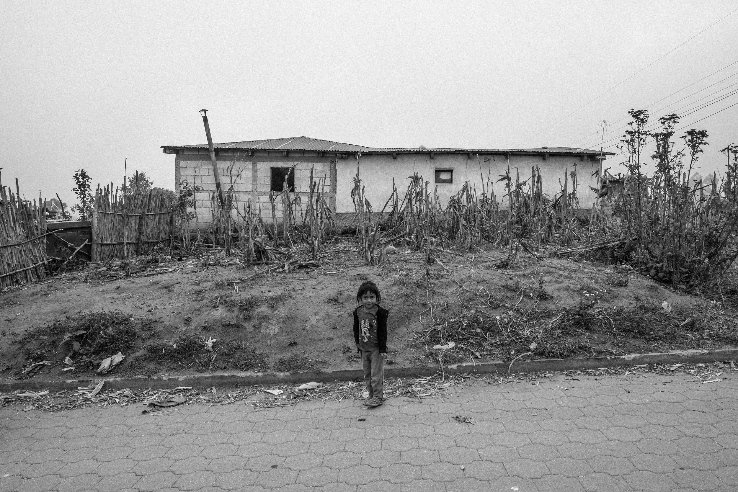 A young Mayan girl stands before her home in the highland village of La Ilusion Chuiquel.