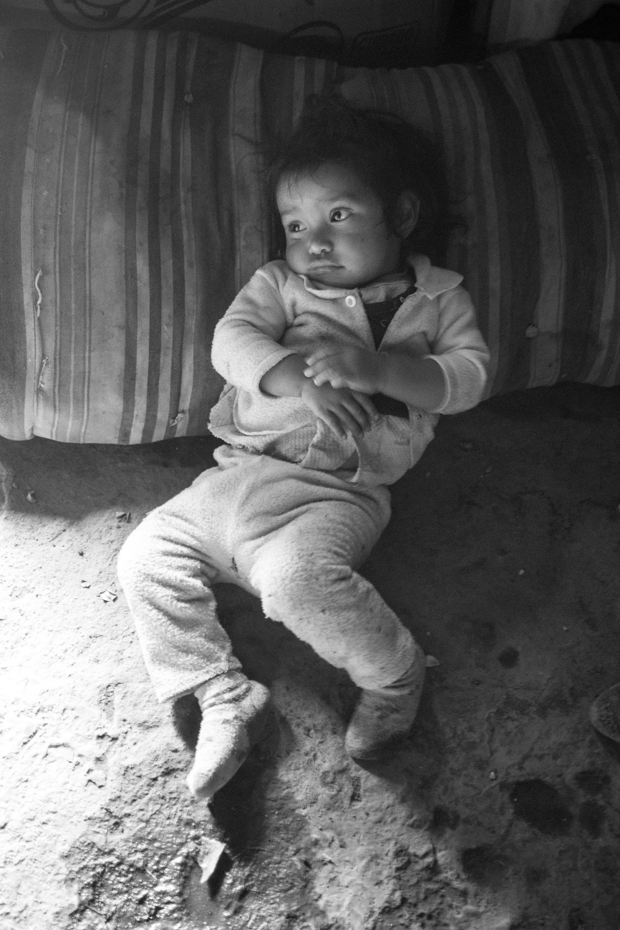 A Mayan child lies on the dirt floor of his home in a highland village just outside the community of San Andrés Itzapa.