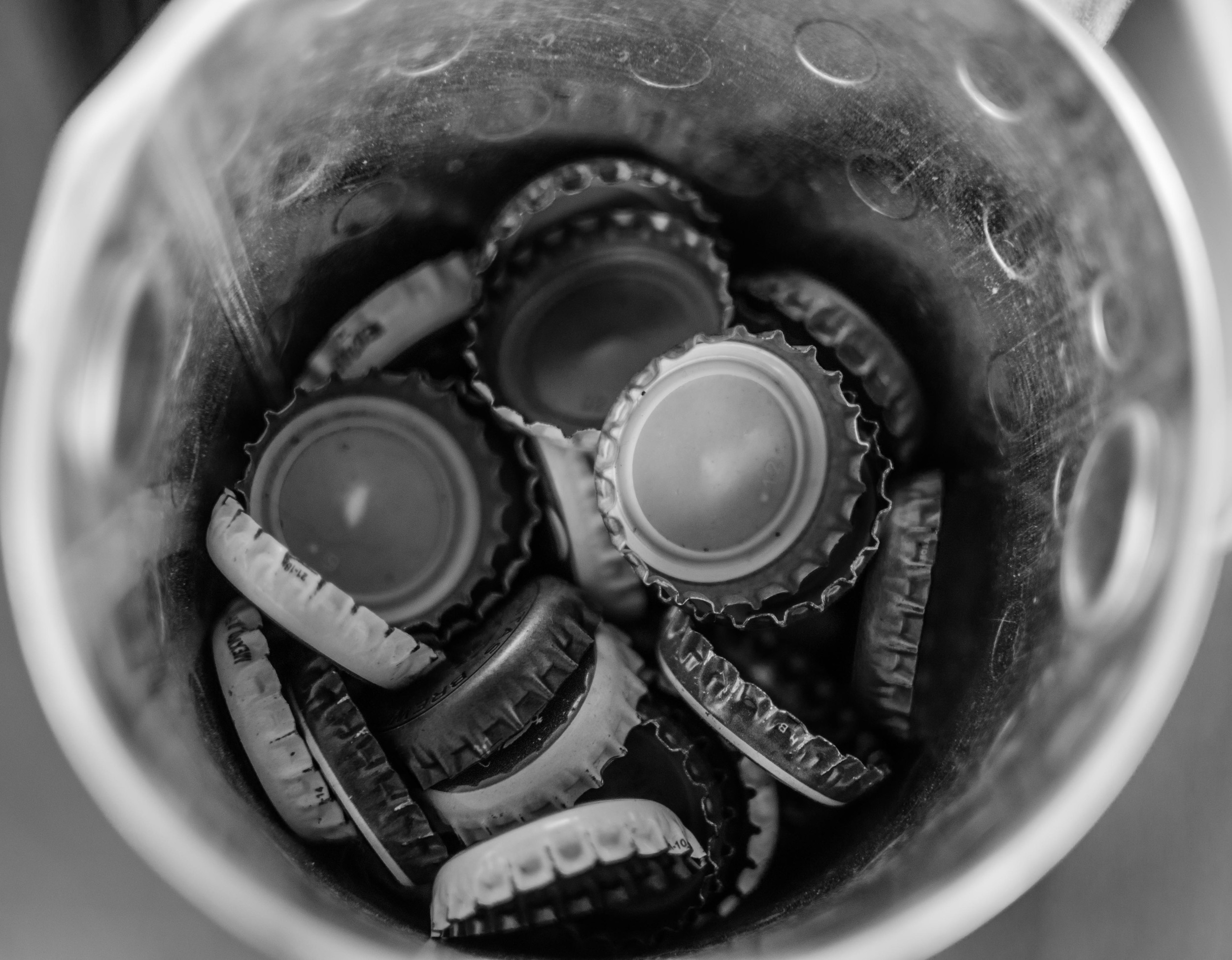 We installed a new bottle opener on our deck and my wife created this makeshift bottle cap catcher. I love the way the edges of the caps look in B&W.