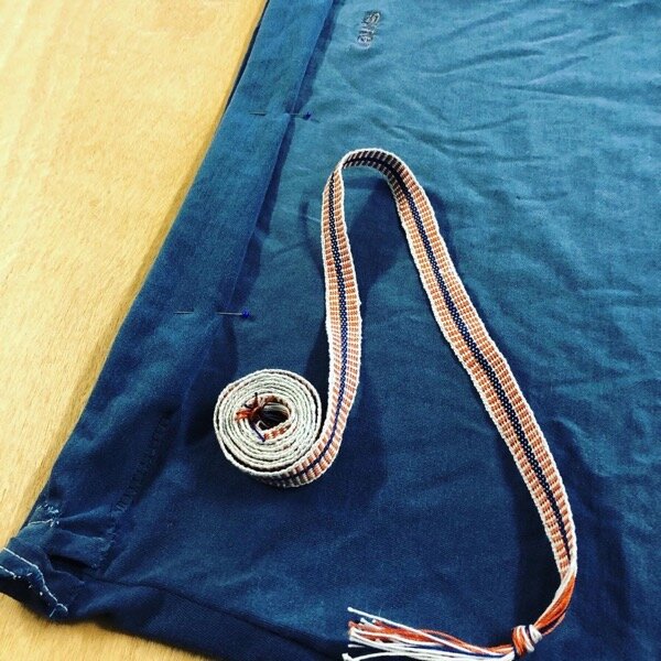 Handwoven crochet cotton tape, spooled on top of a navy blue T-shirt being converted to a skirt.