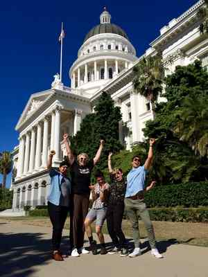 Sara Kelly Keenan, left of center, and Jamie Joy, right of center, pose in front of the state house after speaking in support of SB 179 in July. (Jamie Joy -- Contributed) 