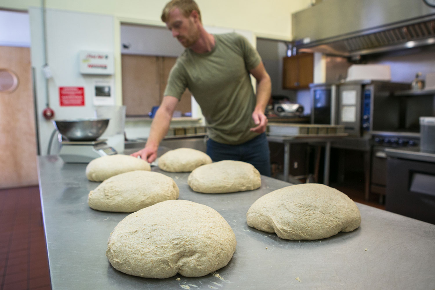 Eliot in the kitchen with loaves of dough ready for the oven