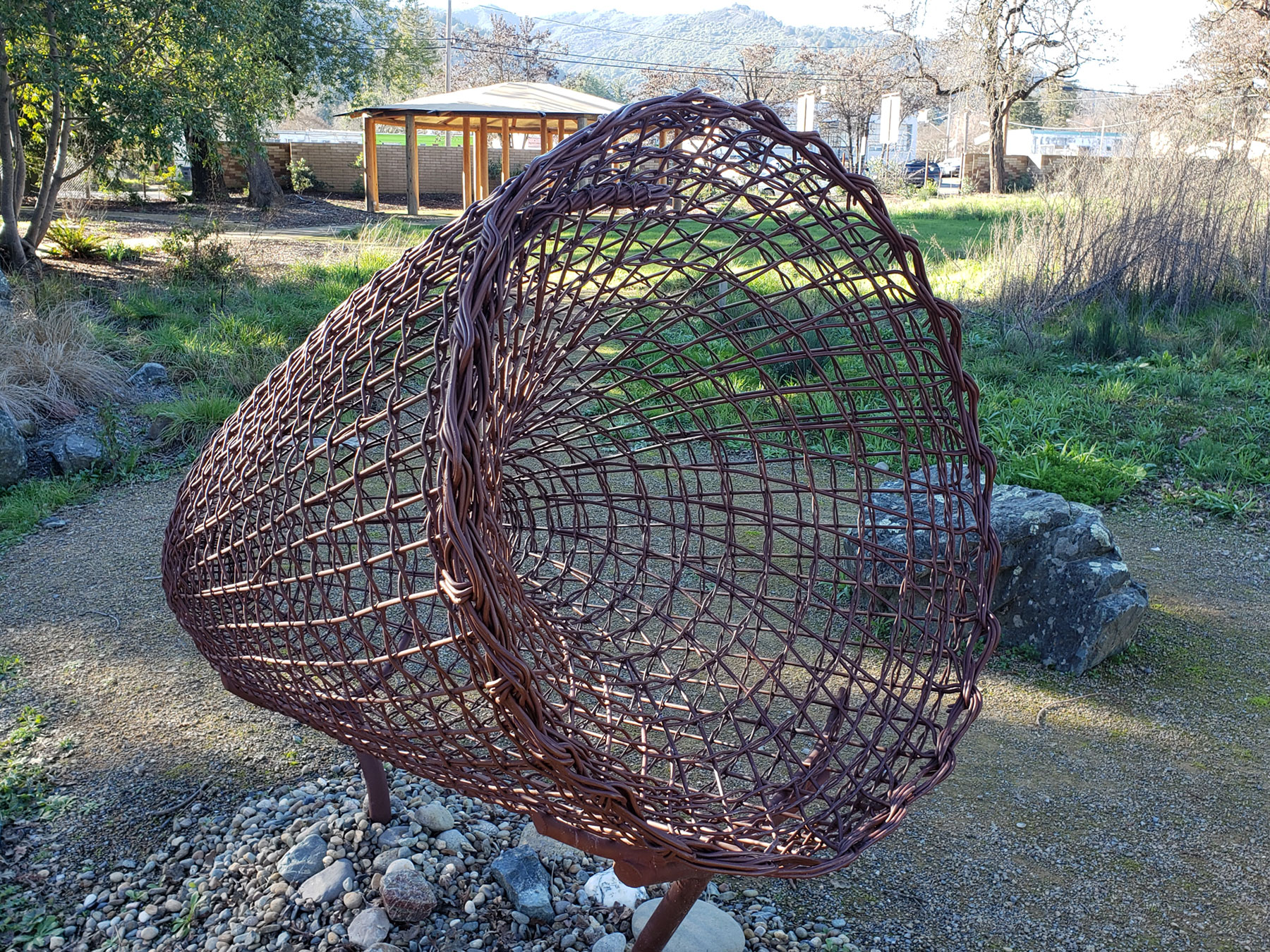 A metal sculpture depicts the design used for a traditional fishing basket. Shoots from the Redbush plant are used in Pomo basket weaving