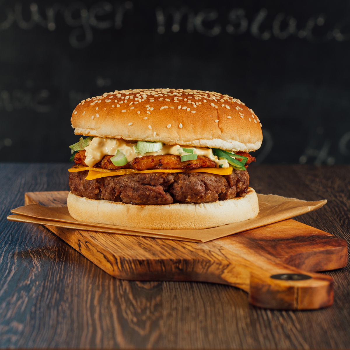 Jarný špeciál burger s hovädzím mäsom, cheddarom, zemiakovou plackou, vajíčkovou pomazánkou a jarnou cibuľkou.