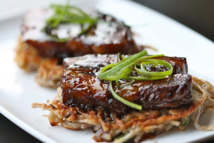 Pork Belly Pancakes nyonya pork belly in sticky soy reduction with taro root pancakes and fresh chives Photo Credit: Caroline Aksich