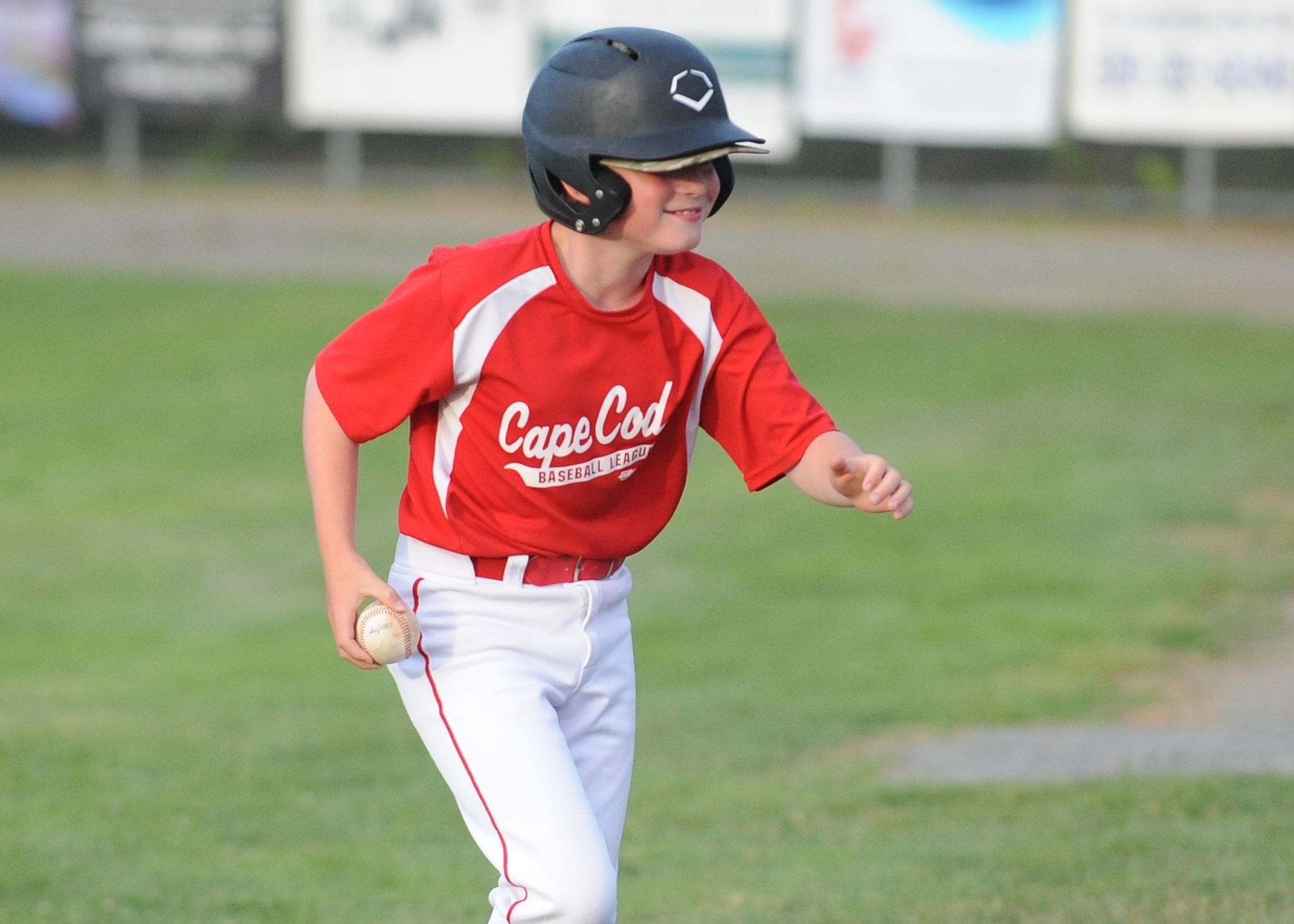 Jason Holmes grabs a foul ball and heads back to the Y-D dugout. Photo by David Colantuono, Wicked Local Cape Cod .