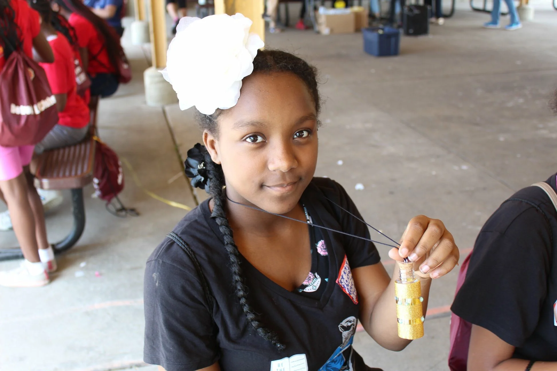 A LitKid shows off her completed "Message in a Bottle" necklace.