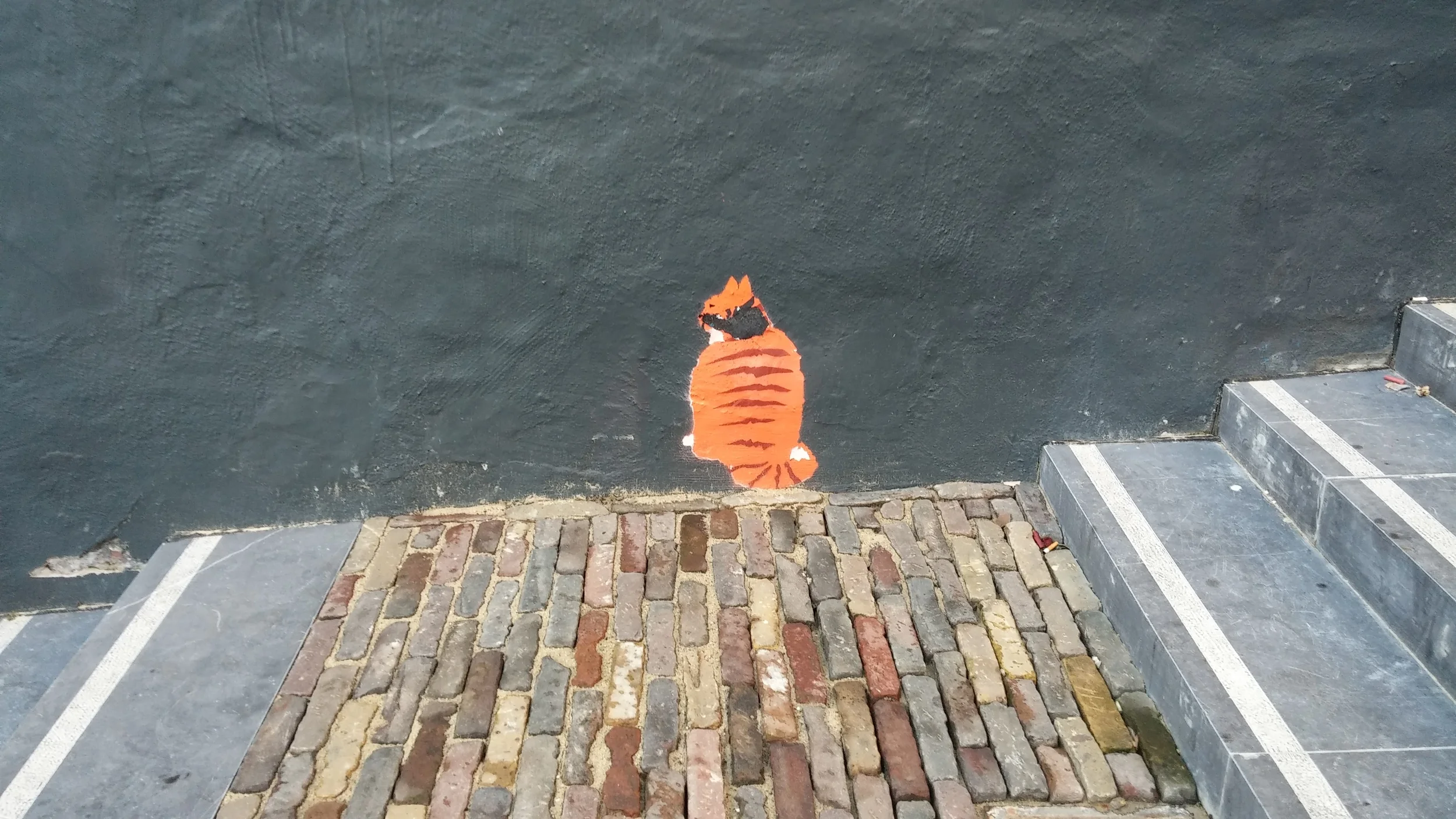 A cat painted on a wall by the church.
