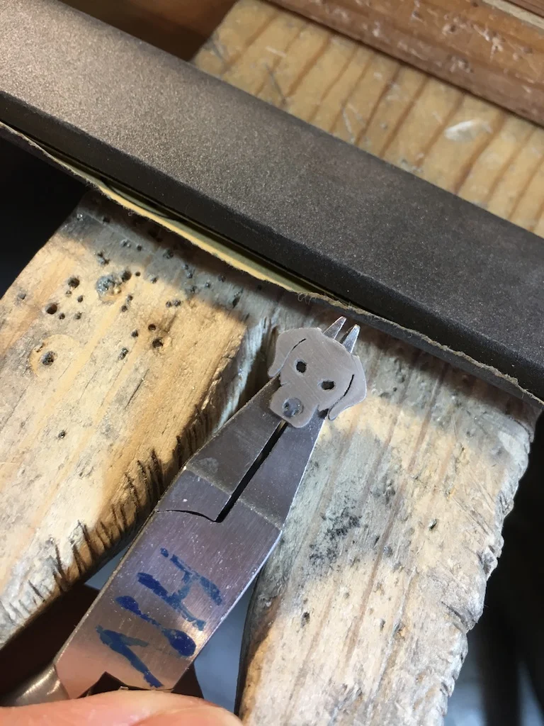 Then I sand off all the patina that's not recessed in the stamped parts.