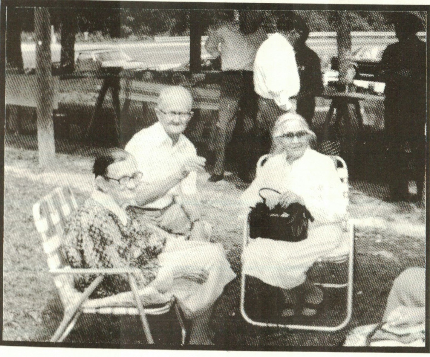 Three siblings chat before the meal. In the background you see the tables laden with food.
