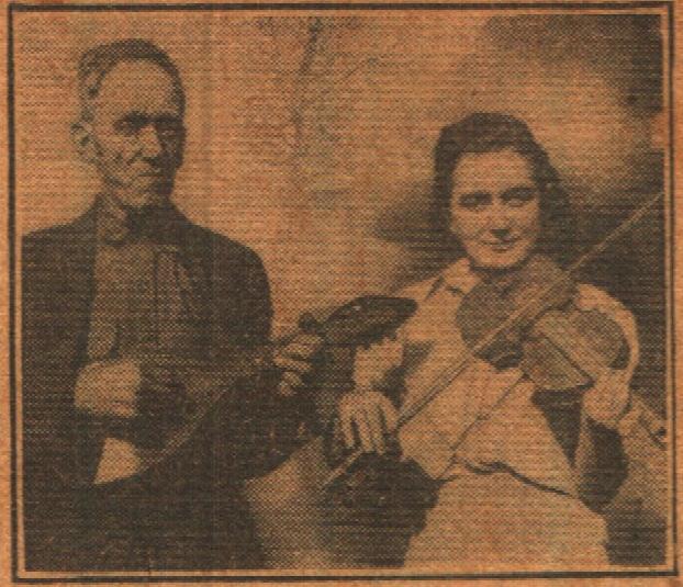T.E. Hixson holding a mandolin made from a gourd; his daughter Opal Hixson holds the match stick fiddle.